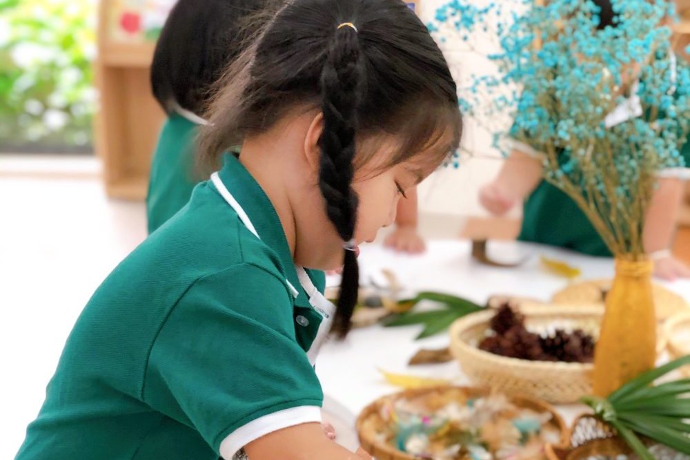 A child exploring leaves and natural materials
