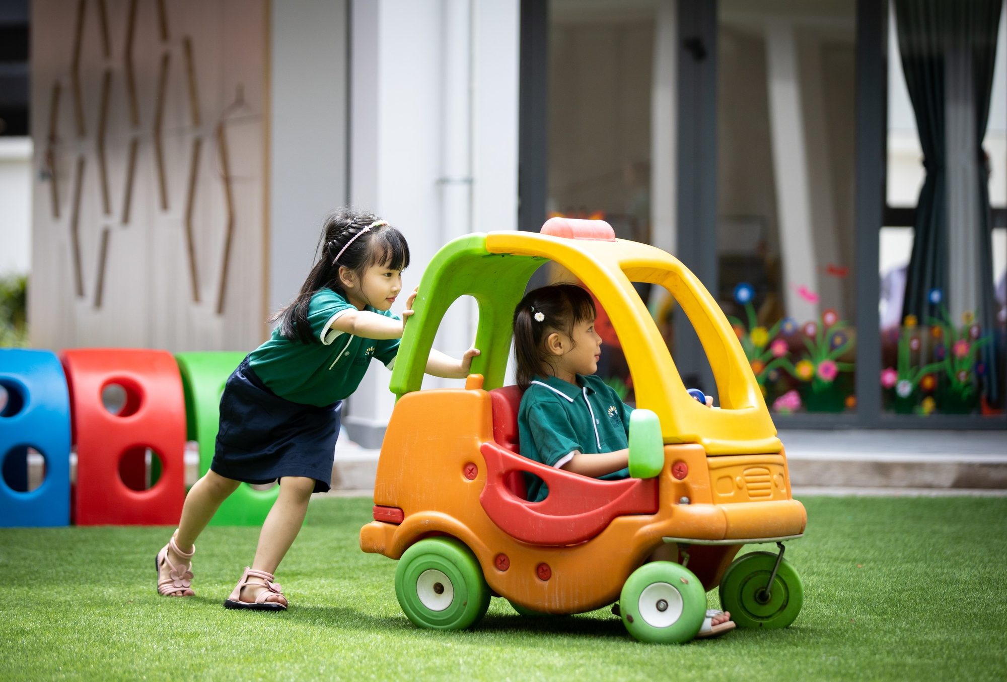Hai bé chơi ô tô đồ chơi trên sân cỏ Hugo House